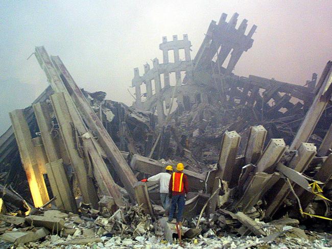 TO GO WITH AFP STORY by Sebastian Smith, US-attacks-911-anniversary-conspiracy (FILES): Rescue workers survey damage to the World Trade Center in this September 11, 2001 file photo in New York. Perhaps the attack was just too huge to comprehend, or the Twin Towers' collapse looked too much like a Hollywood epic, but even 10 years later, many people believe 9/11 was an elaborate conspiracy involving anyone from Israeli agents to the US government itself. AFP PHOTO/Doug KANTER/FILES