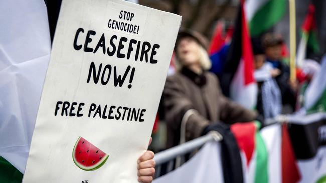 Pro-Palestinian sympathisers wave placards outside the International Court of Justice in The Hague before the hearing of the genocide case against Israel, brought by South Africa. Picture: AFP