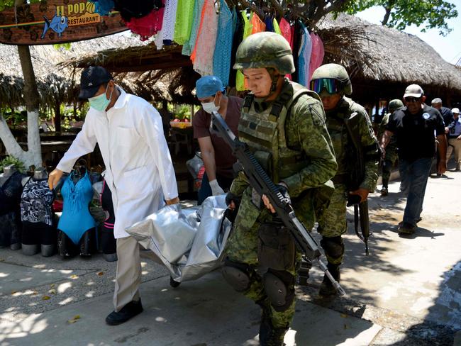 Forensic personnel and Mexican soldiers carry the corpse of the murdered man, who was found in Caletilla Beach, Acapulco on April 15. Picture: Francisco Robles/AFP