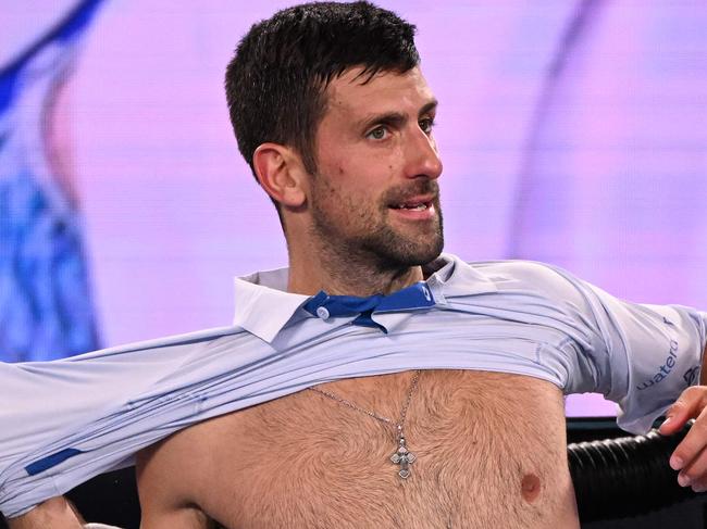 Serbia's Novak Djokovic changes his shirt during a break in his men's singles match against Croatia's Dino Prizmic on day one of the Australian Open tennis tournament in Melbourne on January 14, 2024. (Photo by WILLIAM WEST / AFP) / -- IMAGE RESTRICTED TO EDITORIAL USE - STRICTLY NO COMMERCIAL USE --