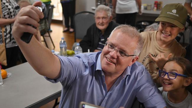 Prime Minister Scott Morrison in a lighter moment with children at the Club Taree Evacuation Centre. Picture: AAP