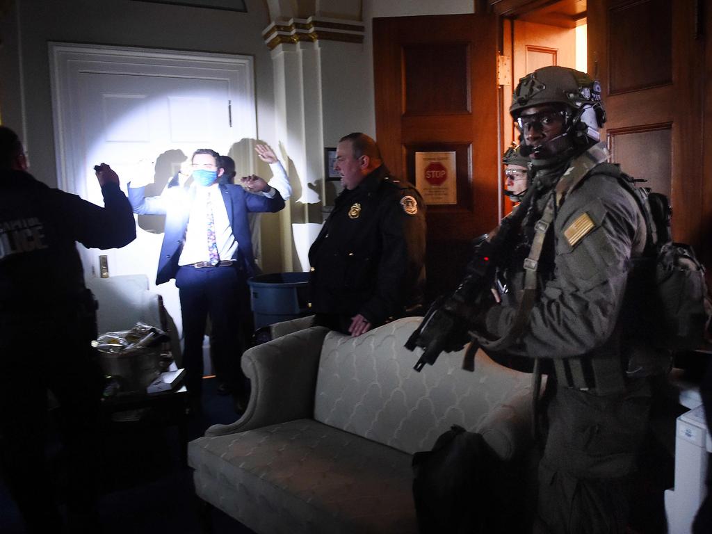 Congress staffers hold up their hands while Capitol Police Swat teams check everyone in the room as they secure the floor of Trump supporters in Washington, DC. Picture: AFP