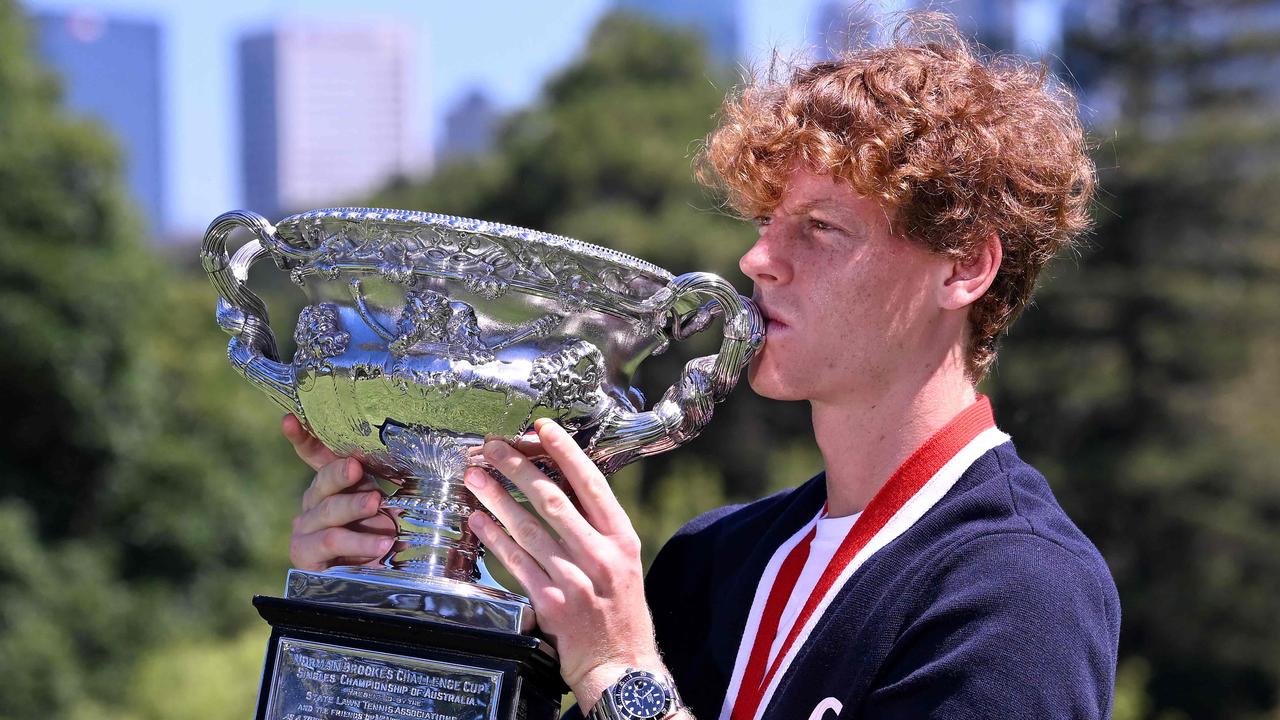 Jannik Sinner poses with the Norman Brookes Challenge Cup trophy. Photo by WILLIAM WEST / AFP.