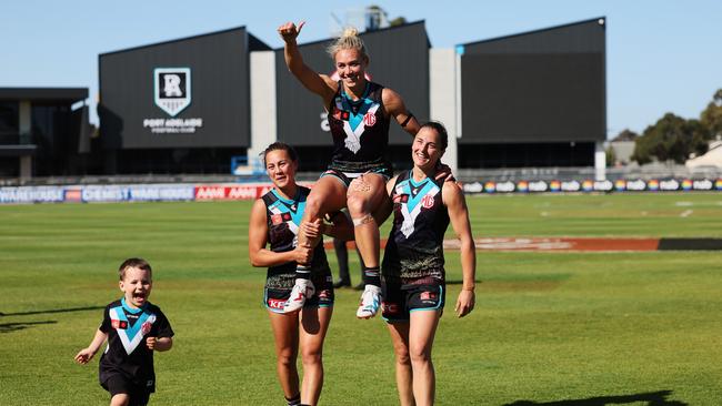 Erin Phillips is chaired off in her last game by Justine Mules and Angela Foley as her son Drew runs past. Photo by James Elsby/AFL Photos via Getty Images