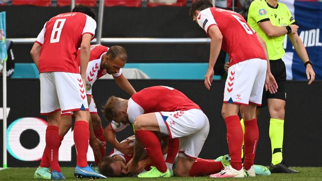 Denmark players help Christian Eriksen after his collapse during the EURO 2020 Group B football match against Finland. Picture: AFP