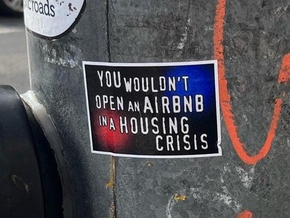 The sticker reads ‘You wouldn't open an Airbnb in a housing crisis’. Picture: Reddit