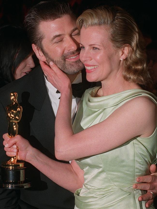 Holding her Oscar, Kim Basinger gives husband Alec Baldwin an affectionate touch in 1998. Picture: AP