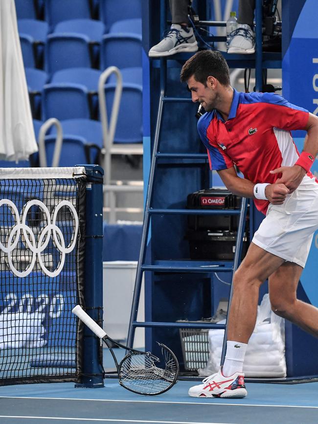 Serbia's Novak Djokovic smashes his racket.