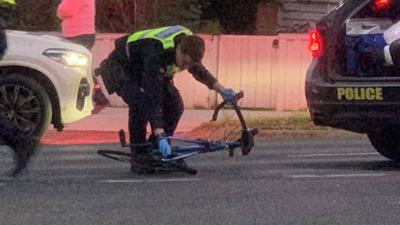 A police officer removes the bike. Picture: Lincoln Holmes.