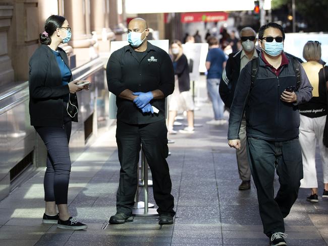 BRISBANE , AUSTRALIA - NewsWire Photos August 7, 2020: Security guards at the Apple store in Brisbane City wear protective masks, Friday August 7,2020. The store wonÃt let the public in without a mask and are taking temperatures at the door. Picture: NCA NewsWire / Sarah Marshall