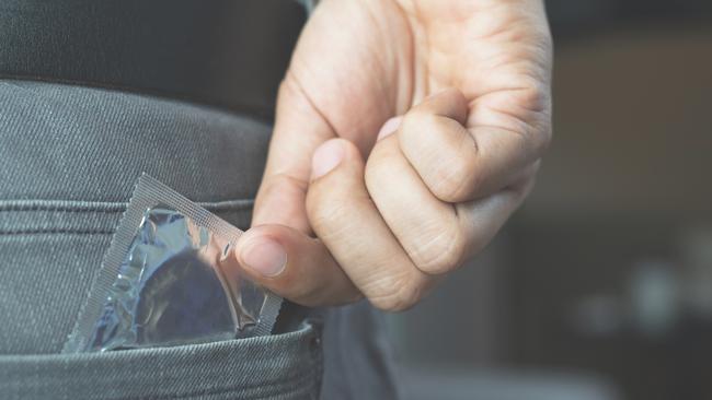 Condom ready to use in male hand, give condom safe sex concept on the bed Prevent infection and Contraceptives control the birth rate or safe prophylactic. World AIDS Day, Leave space for text.