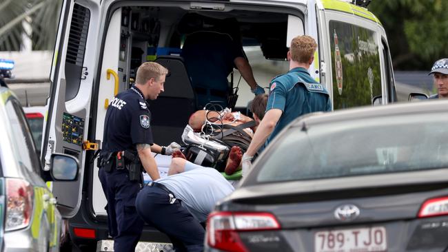 Police establish a crime scene at a Woomala Street residence in Woree where 38-year-old woman Crystal Ratcliffe was pronounced dead and partner Ricky Cowan, 48, (pictured being taken to an ambulance, was critically injured, both suffering stab wounds). Picture: Marc McCormack