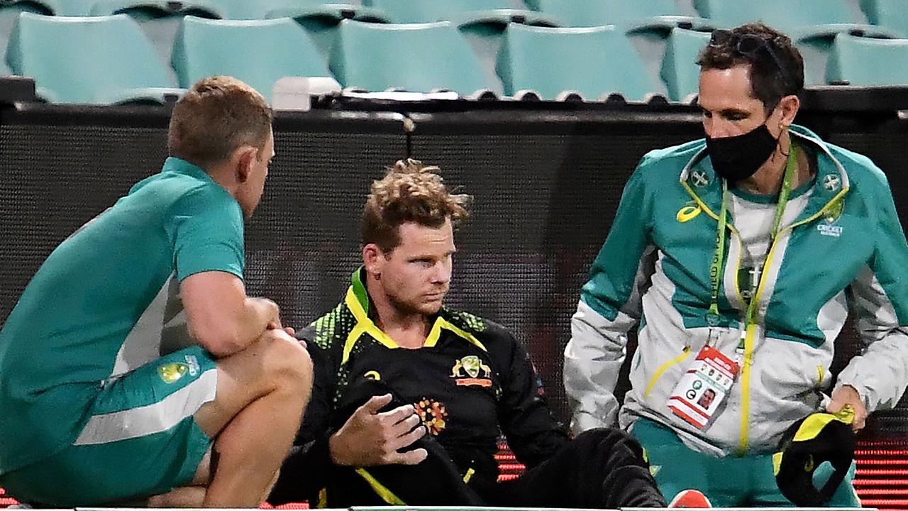 Australia's Steve Smith (C) gets medical attention after hitting his head against the ground in an attempt to catch the ball. Picture AFP
