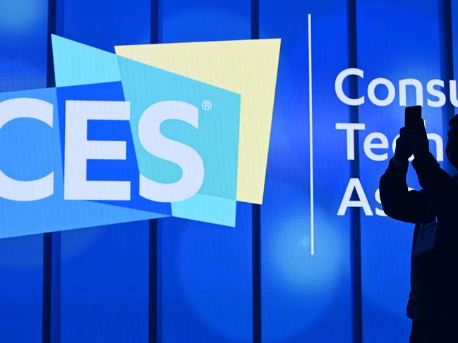 An attendee photographs a sign next to the CES logo ahead of the first keynote address at the 2020 Consumer Electronics Show (CES) on January 6, 2020 in Las Vegas, Nevada. - CES is one of the largest tech shows on the planet, showcasing more than 4,500 exhibiting companies representing the entire consumer technology ecosystem. (Photo by Robyn Beck / AFP)