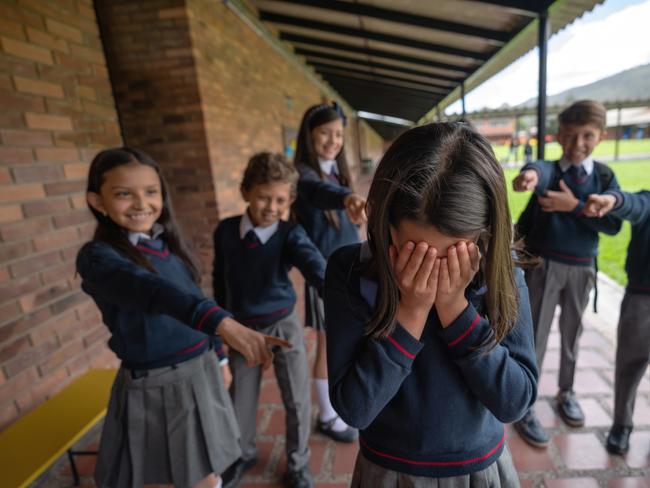 Group of Latin American students bullying a girl at the school - education concepts