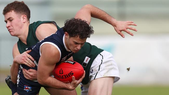Ballarat’s Mitch Fino is tackled by Hampden’s Hamish Cook. Picture Yuri Kouzmin