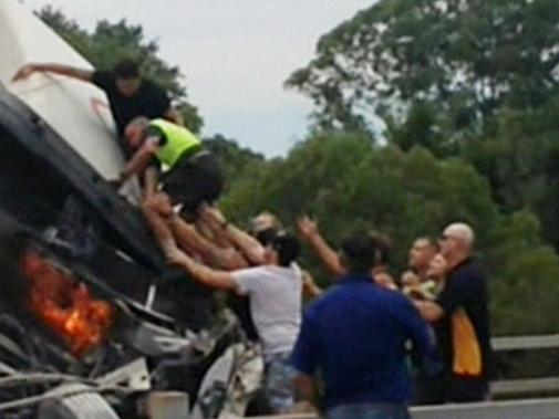 Channel 9 screengrab of a truck driver being rescued by Athen Barnaby at Nerang on the M1