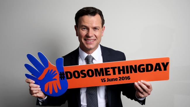 Mark Ferguson holding a #dosomethingday sign at the Bankstown Sports Club. Picture: Richard Dobson