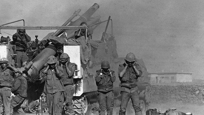 Israeli soldiers plug their ears as they fire shells from a French-made 155mm Horwitzer gun at the Syrian front lines on the Syrian Golan Heights during Yom Kippur War, 17/10/73. Picture: Historical Israel