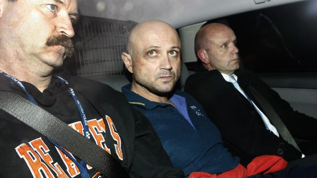 Chris Binse (centre) in police custody after his last arrest in 2012.