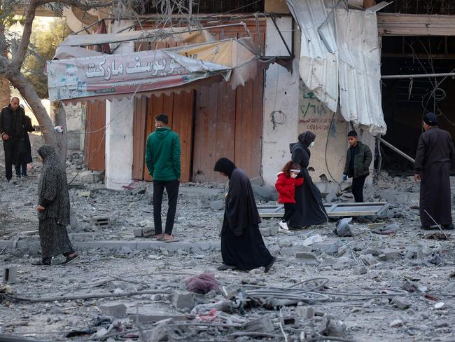 Palestinians walk amid the rubble in front of a building destroyed in an Israeli airstrike in Nuseirat in the central Gaza Strip on December 1, 2024, amid the ongoing war between Israel and Hamas militants. Picture: AFP