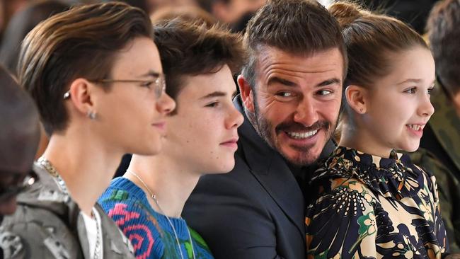 TOPSHOT - Sons of David and Victoria Beckham, Romeo Beckham (2nd L) and Cruz Beckham (3rd L), David Beckham (C) and his daughter Harper (2nd R) take their seats in the front row for the catwalk show by fashion house Victoria Beckham during their Autumn/Winter 2020 collection on the third day of London Fashion Week in London on February 16, 2020. (Photo by DANIEL LEAL-OLIVAS / AFP)