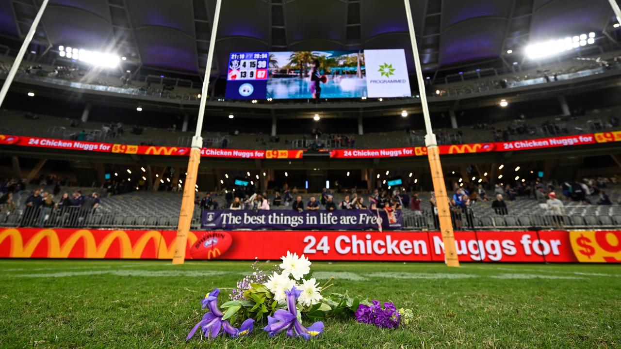 Flowers are laid for Cam McCarthy by Nat Fyfe and Alex Pearce of the Dockers. (Photo by Daniel Carson/AFL Photos via Getty Images)