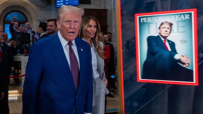 Donald Trump poses in front of Time Magazine mock cover. Picture: AFP