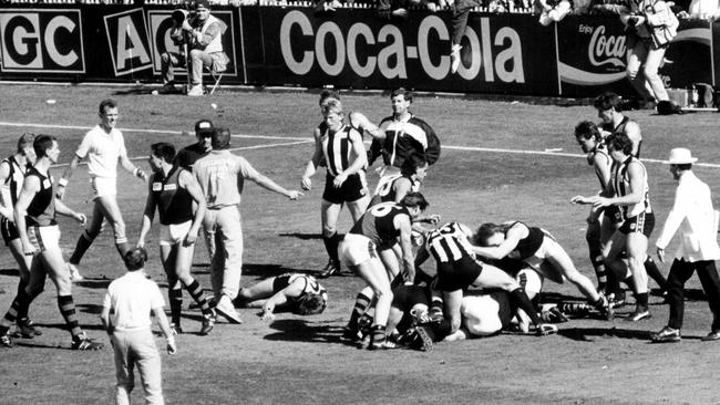 Gavin Brown lies on the ground amid the chaos of the quarter-time brawl in the 1990 Grand Final. Picture: Clive Mackinnon