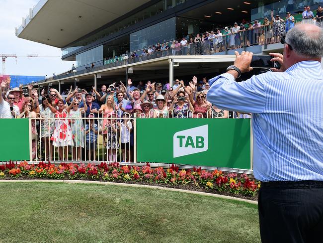 Trainer Rob Heathcote takes pictures of the many owners after Dusty Tycoon won at Doomben. Picture: Trackside Photography