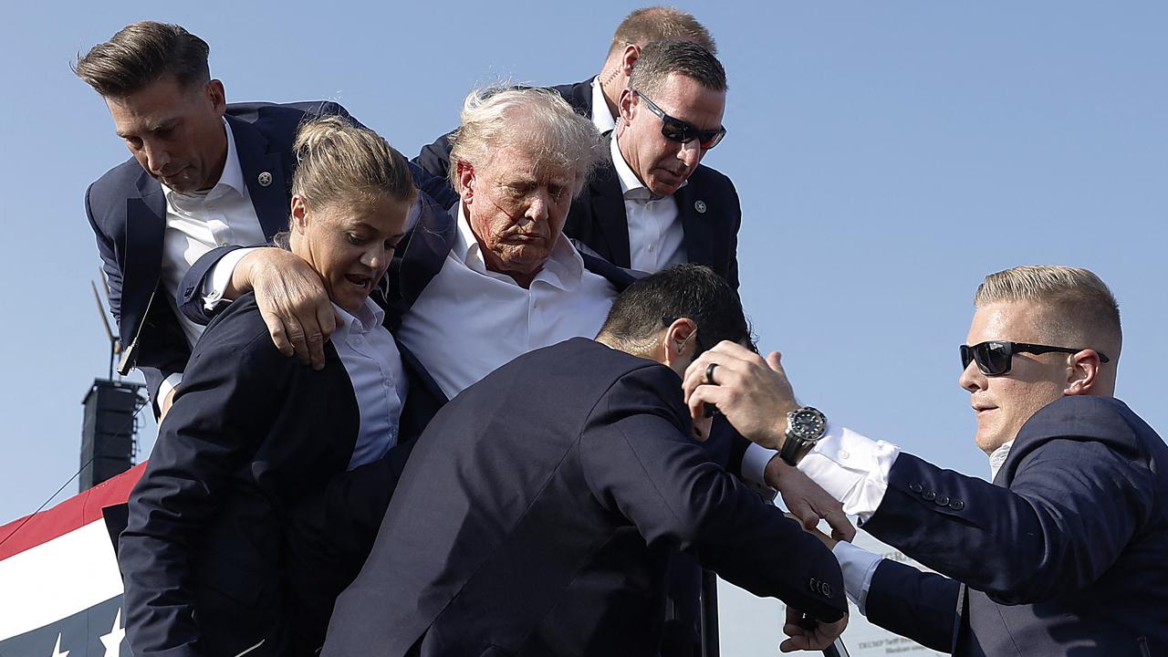 Donald Trump is rushed from the stage after being struck by an attempted assassin’s bullet while speaking at a campaign rally. Picture: Getty Images