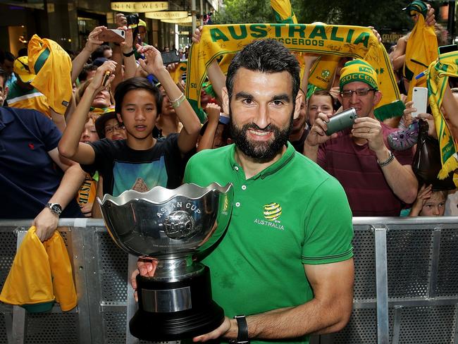 Socceroos captain Mile Jedinak with the Asian Cup trophy in front of cheering fans. Picture: Getty Images