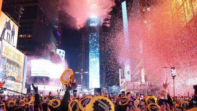 Onlookers watch as confetti fills the air to mark the beginning of the new year, in Times Square, New York City, on January 1, 2023. (Photo by Yuki IWAMURA / AFP)