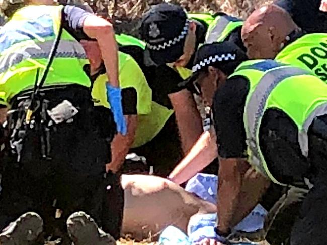 Emergency services attend to a man before he is loaded into an ambulance.  Rainbow Serpent Festival.  Picture: No byline please.