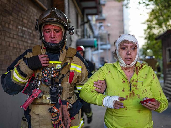 A rescuer helps an injured woman after several strikes hit the Ukrainian capital of Kyiv, amid Russia's invasion of Ukraine. Picture: State Emergency Service of Ukraine / AFP