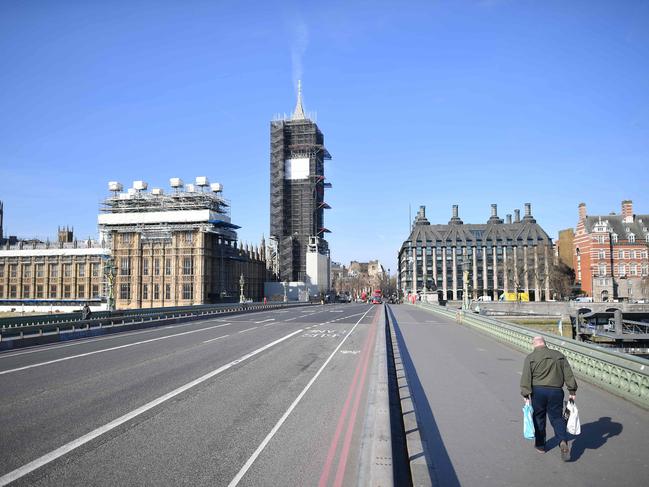 A lone pedestrian heads toward the Houses of Parliament in central London, March 24. Picture: Justin Tallis/AFP