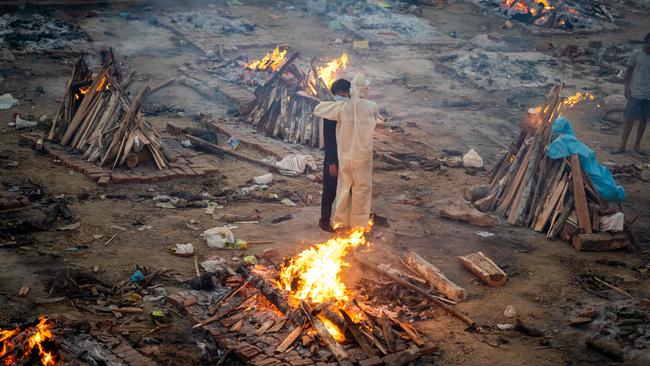 Family members embrace each other amid burning pyres of victims who lost their lives due to the COVID-19 coronavirus at a cremation ground in New Delhi in India. Picture: Jewel SAMAD / AFP