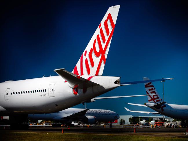 Virgin Australia aircraft are seen parked on the tarmac at Brisbane International airport on April 21, 2020. - Cash-strapped Virgin Australia collapsed on April 21, making it the largest carrier yet to buckle under the strain of the coronavirus pandemic, which has ravaged the global airline industry. (Photo by Patrick HAMILTON / AFP)