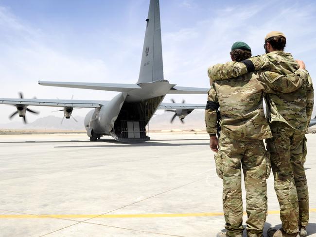 Two special forces soldiers embrace as the C-130 carrying Sergeant Brett Wood departs Tarin Kowt Airfield on May 28, 2011. Picture: Australian Navy Able Seaman Jo Dilorenzo