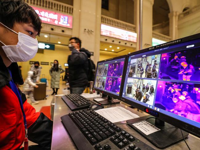 A staff member screens arriving passengers with thermal scanners at Hankou railway station in Wuhan. Picture: AFP