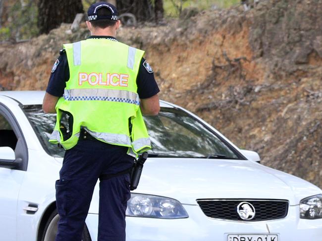 BURLEIGH WEST , AUSTRALIA - NewsWire Photos March 31, 2021: Uniformed Queensland Police traffic officers wearing face masks stop and check vehicles east bound on West Burleigh Road, Burleigh West .Picture: NCA NewsWire / Scott Powick