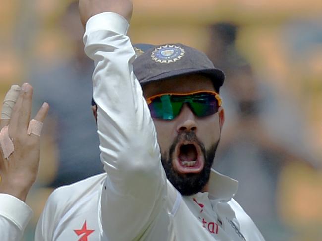 Indian bowler Umesh Yadav (2R) celebrates with captain Virat Kohli (C) and his team mates, the dismissal of Australian captain Steve Smith during the fourth day of the second Test match between India and Australia at The M. Chinnaswamy Stadium in Bangalore on March 7, 2017. / AFP PHOTO / Manjunath KIRAN / ----IMAGE RESTRICTED TO EDITORIAL USE - STRICTLY NO COMMERCIAL USE----- / GETTYOUT