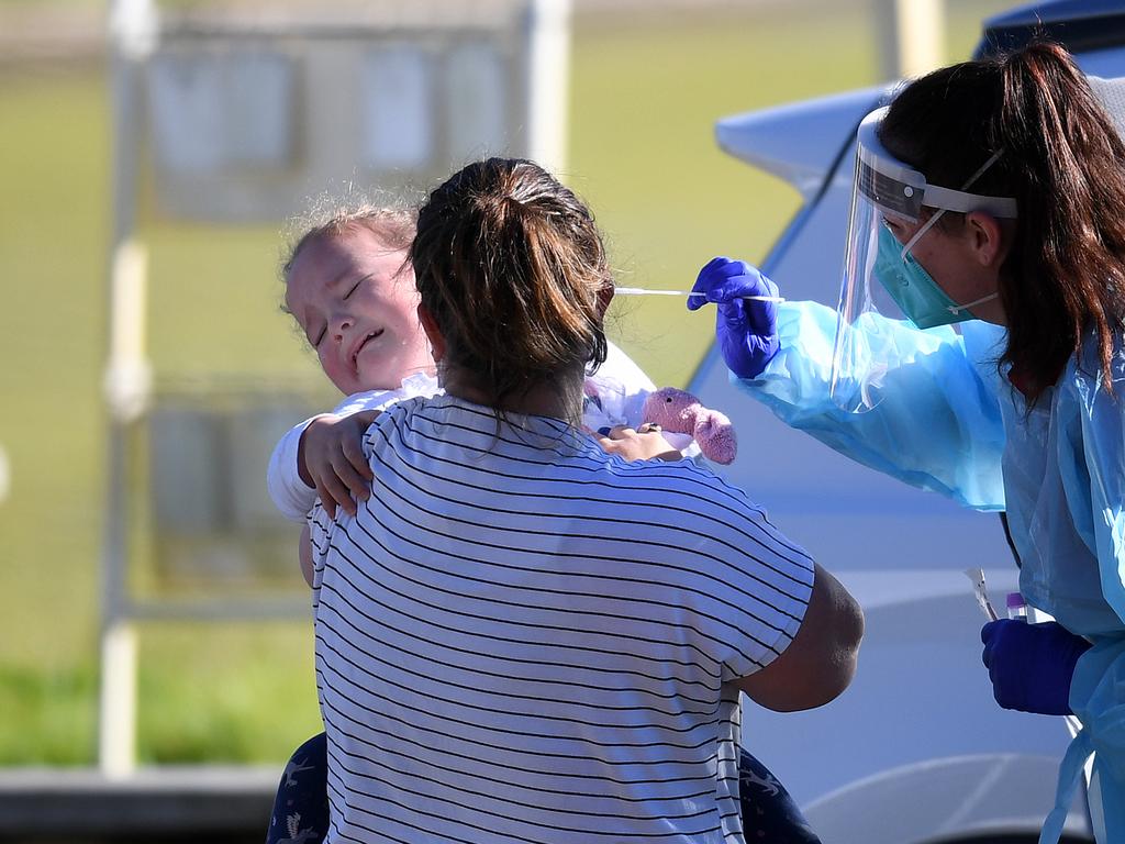 A health worker attempts to swab an unhappy toddler at a pop up Covid-19 testing clinic in Toowong. Picture: NCA NewsWire / Dan Peled