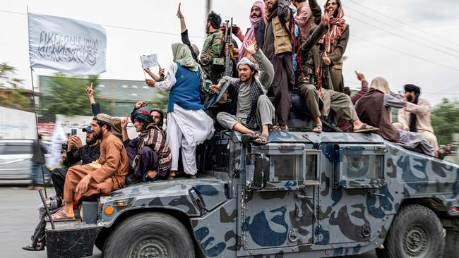 TOPSHOT – Taliban fighters hold weapons as they ride on a humvee to celebrate their victory day near the US embassy in Kabul on August 15, 2022. – Taliban fighters chanted victory slogans next to the US embassy in Kabul on August 15 as they marked the first anniversary of their return to power in Afghanistan following a turbulent year that saw women's rights crushed and a humanitarian crisis worsen. (Photo by Wakil KOHSAR / AFP)