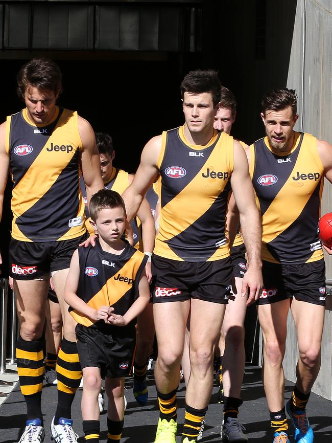 Trent Cotchin leads Richmond out ahead of the 2014 elimination final.