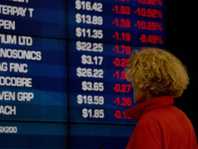 A visitor to the Australian Securities Exchange (ASX) looks at share prices on a big screen in Sydney on October 11, 2018. - The Australian share market joined the regional bloodbath after the sell off on Wall Street, plunging to a more than five-month low as all sectors dropped into the red. (Photo by PETER PARKS / AFP)