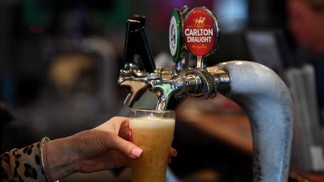 A barmaid pours Australian beers Carlton Draft and Coopers Pale Ale at a bar on International Beer Day in Melbourne, Friday, August 4, 2017. According to internationalbeerday.com, International Beer Day was first celebrated in 2008 and occurs on the first Friday of August. They say it is a global celebration of beer to celebrate brewers and bartenders and, of course, beer. (AAP Image/Tracey Nearmy) NO ARCHIVING