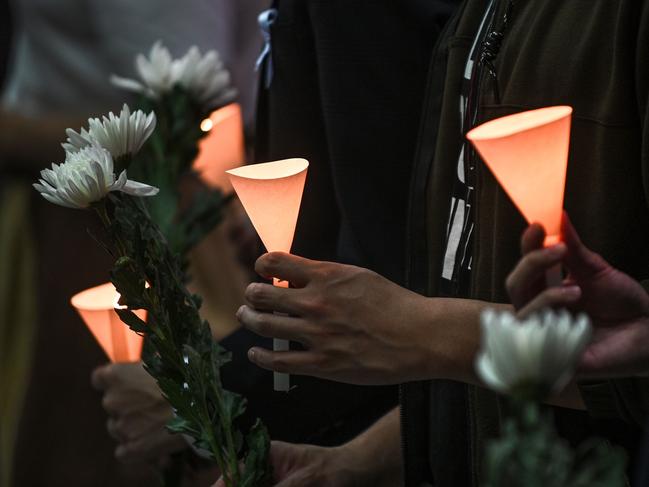 People light candles and hold flowers during a vigil at the Hong Kong University of Science and Technology for student Alex Chow, 22. Picture: AFP