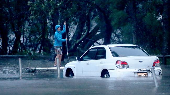 A person on a paddle board on flooded Goodwin St, Narrabeen, near Narrabeen Lagoon, during a flood event in February, 2020. Picture: Damian Shaw