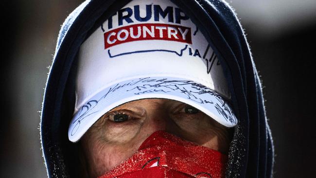 A supporter of former US president and Republican presidential hopeful Donald Trump braves the below zero temperatures to attend a "commit to caucus rally" in Indianola, Iowa, on January 14, 2024. (Photo by Jim WATSON / AFP)